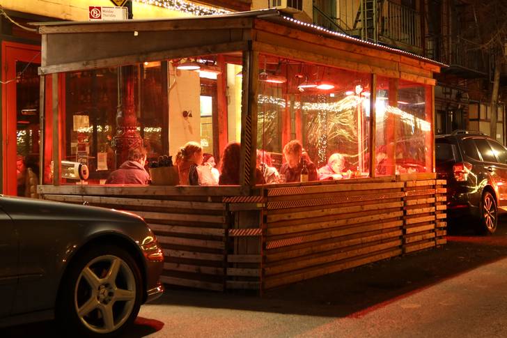 People eat dinner in an outdoor sidewalk shed at a restaurant on Bedford Street in Greenwich Village on Dec. 17, 2021 in New York City.